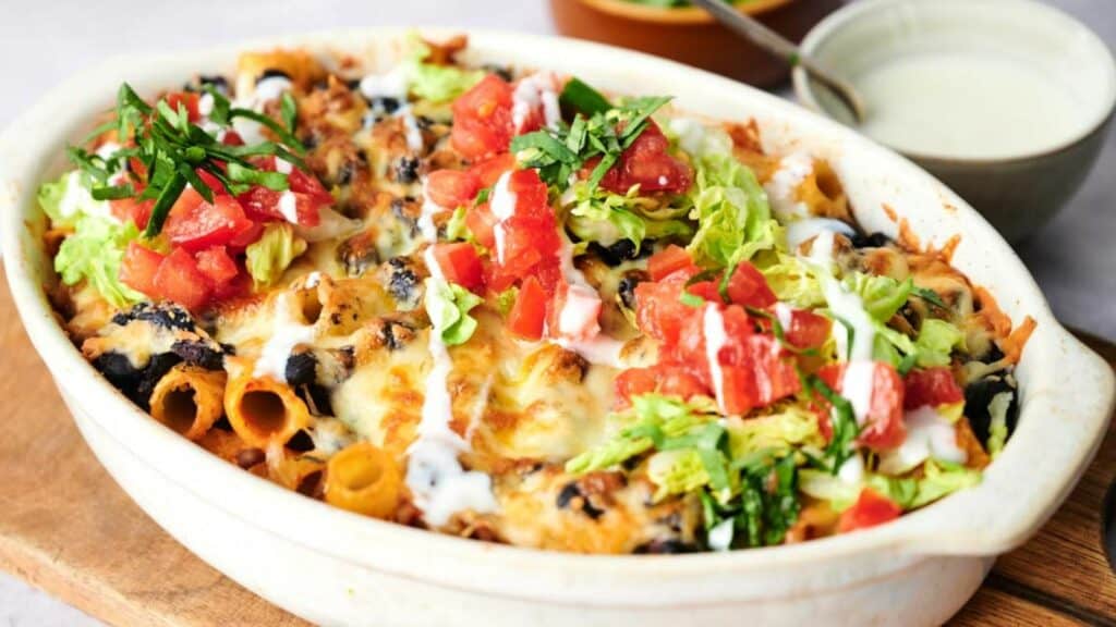 Mexican lasagna, also known as walking taco casserole, is beautifully presented on a rustic wooden cutting board.