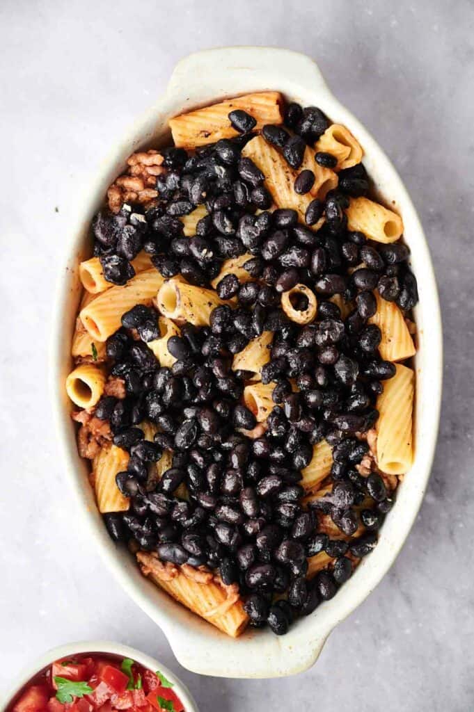 A walking taco casserole with black beans and pasta in it.