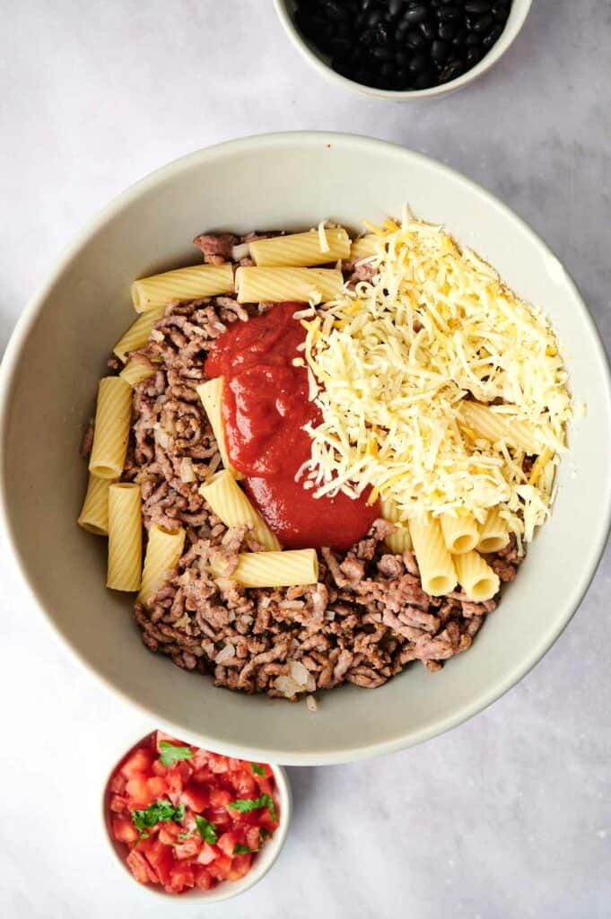 A big bowl with meat, tomatoes and cheese.