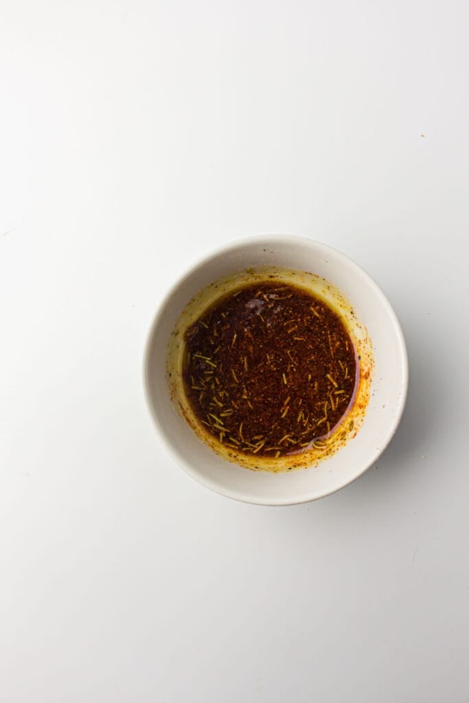 A white bowl with seasonings for an air fryer whole chicken recipe.