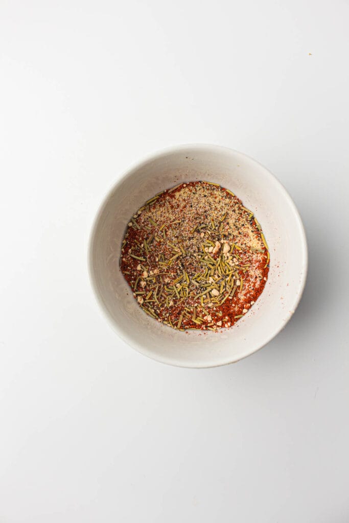 A white bowl with seasonings for an air fryer whole chicken recipe.