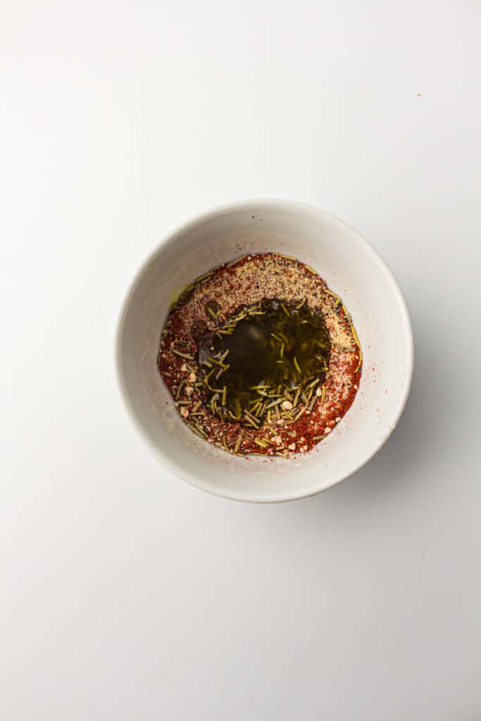 A white bowl with seasonings for an air fryer whole chicken recipe.