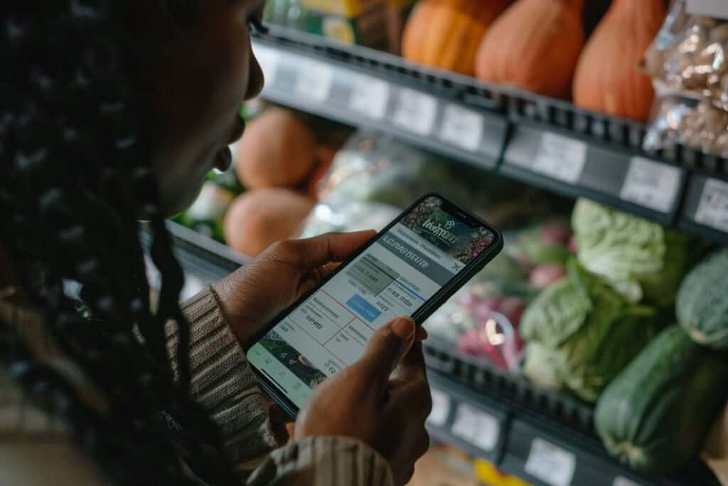 A woman using a smartphone in a grocery store.
