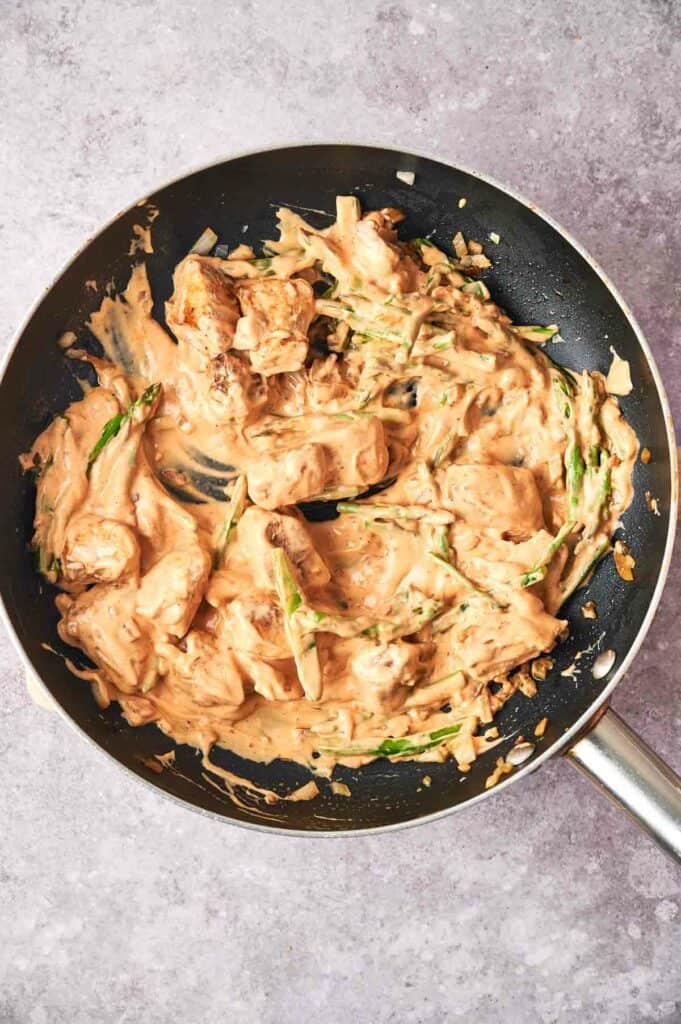 A frying pan with chicken in a chipotle sauce.