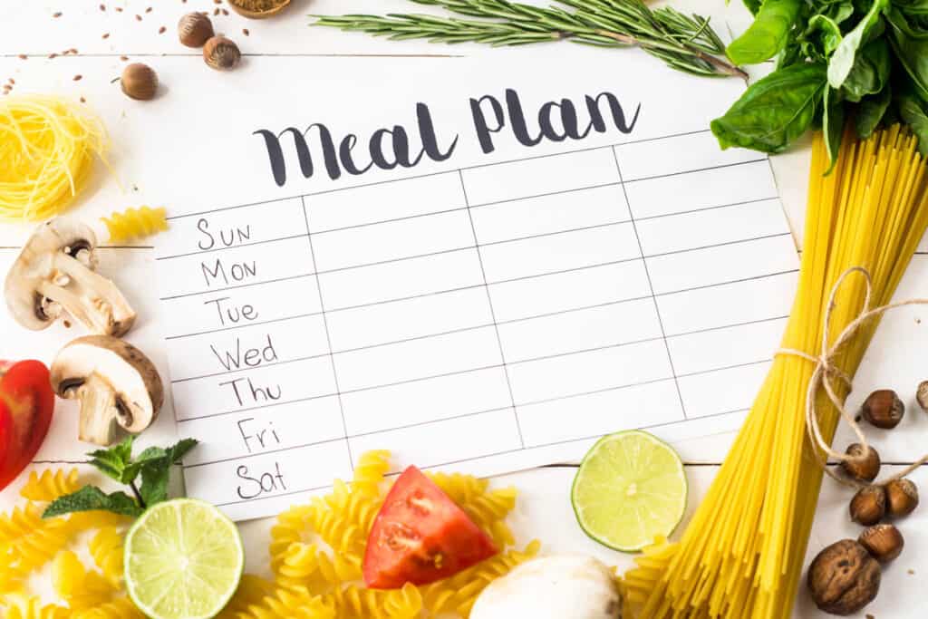 A meal plan with vegetables and pasta on a white background.
