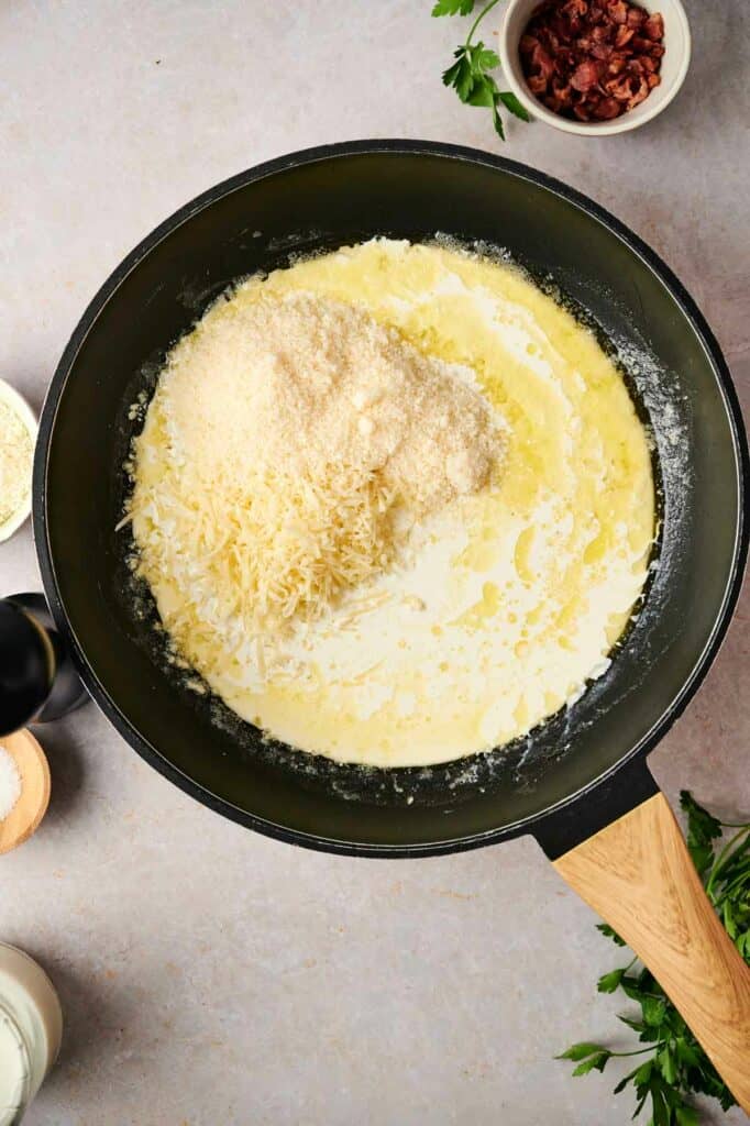 A frying pan with cheese and milk for a ravioli carbonara recipe.