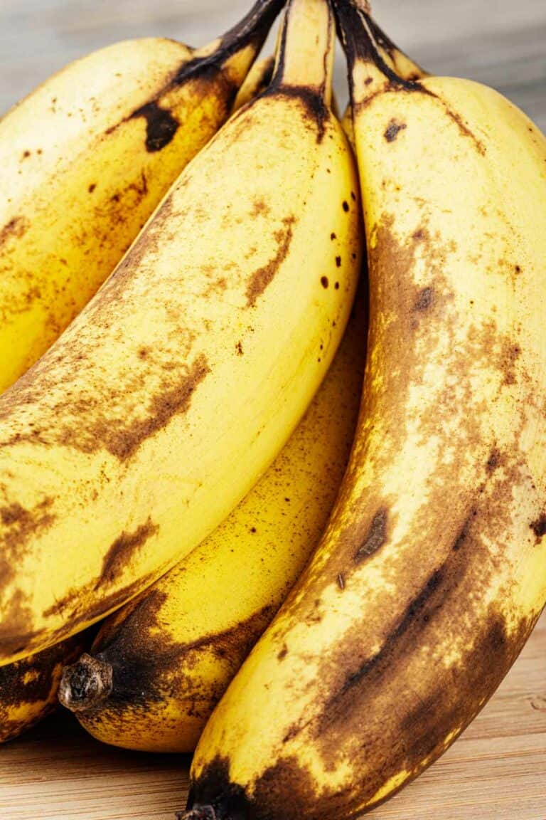 A bunch of bananas on a wooden table.