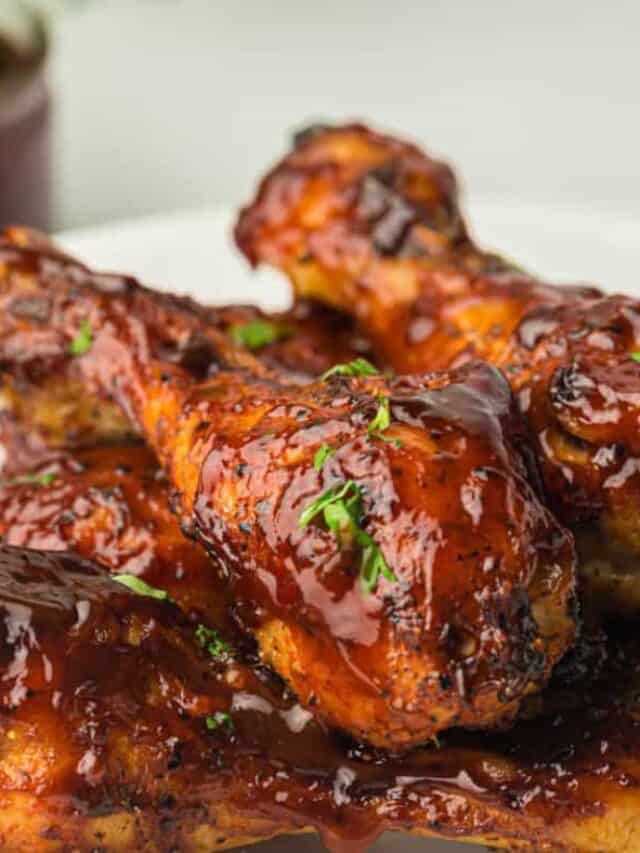 Air fryer chicken wings with bbq sauce on a white plate.