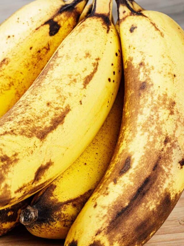 A bunch of ripe bananas on a wooden table.
