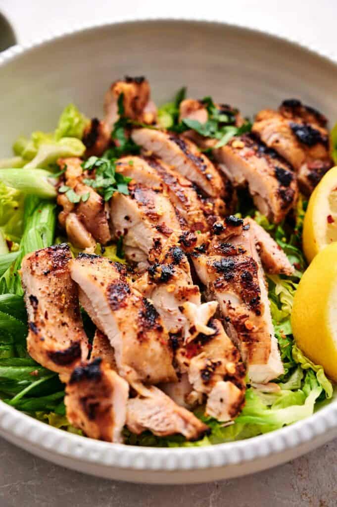 Chipotle Grilled Chicken with slices of lemon in a bowl.