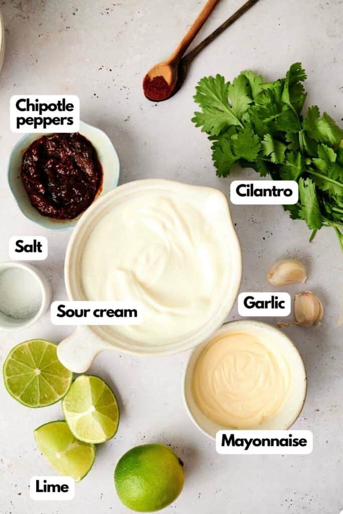 Ingredients for a creamy chipotle sauce on a kitchen surface.