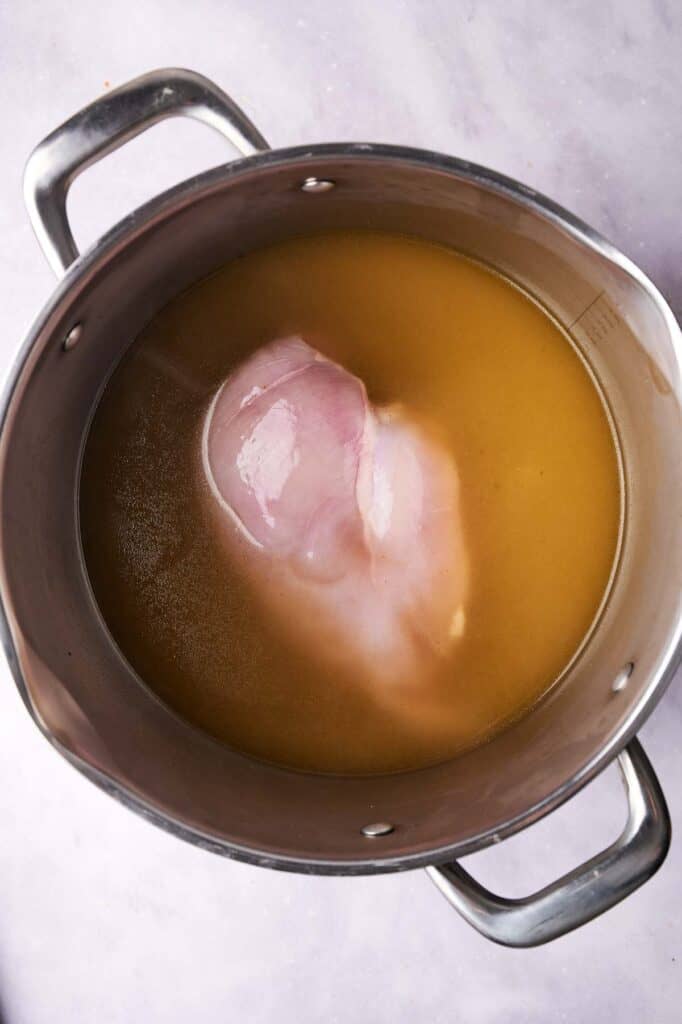 A large pot containing broth with the Cracker Barrel Chicken and Dumplings submerged in it.