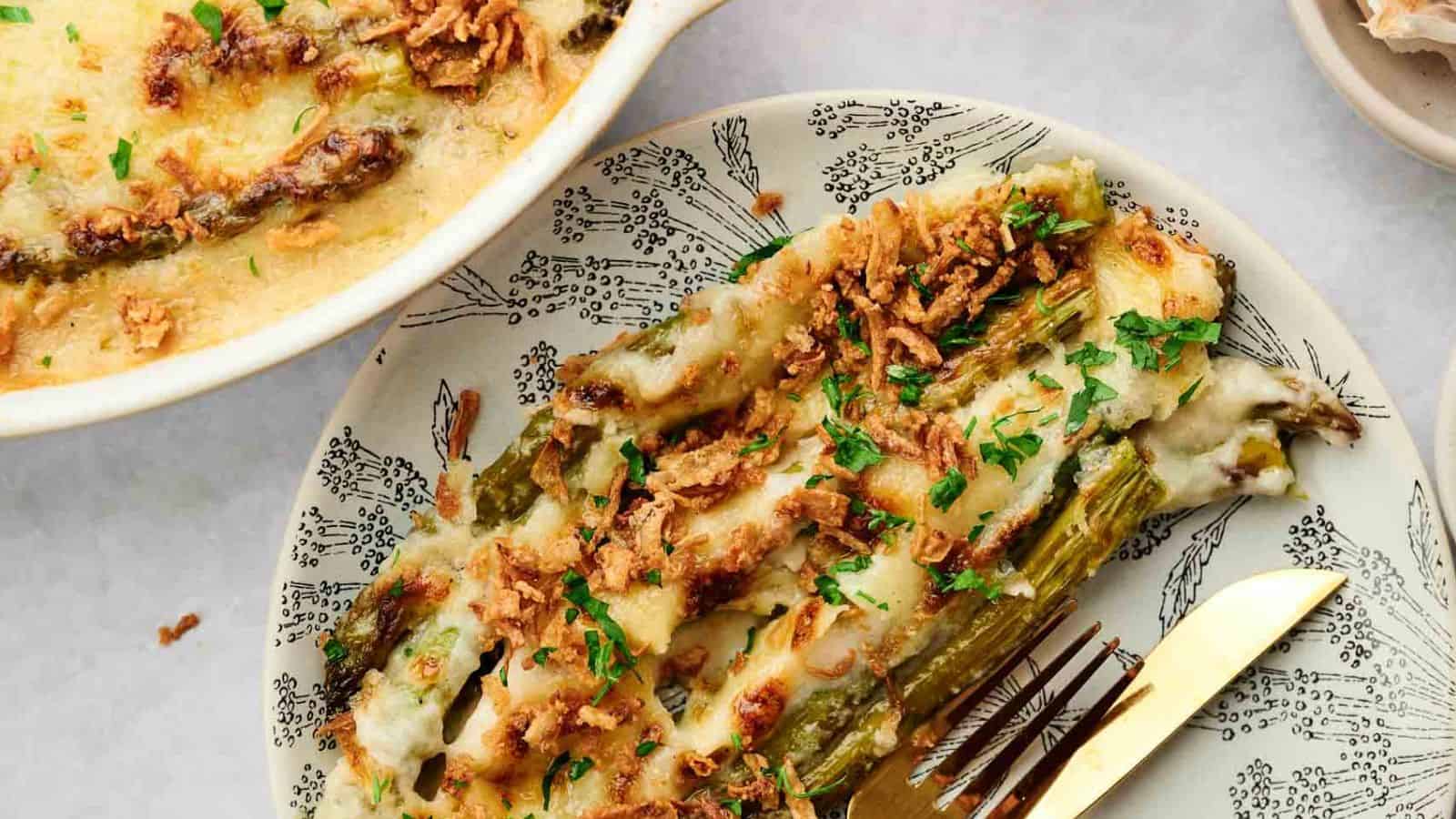 Cheesy asparagus casserole on a plate with a fork.