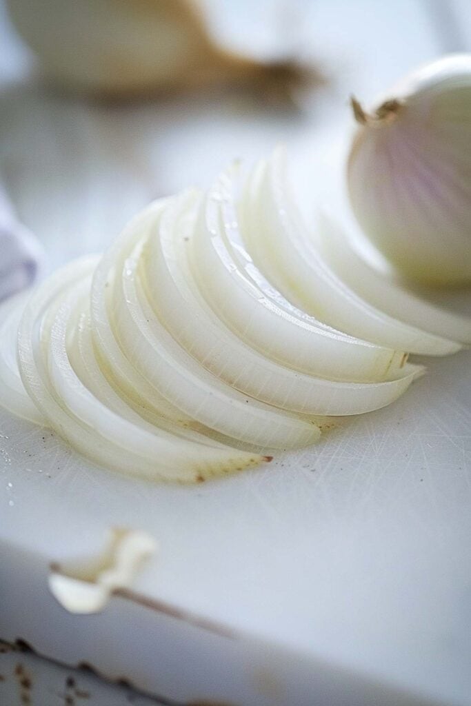 Sliced white onion on a cutting board.
