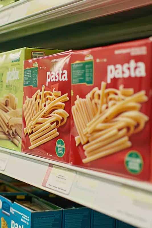 Boxes of pasta on a supermarket shelf.