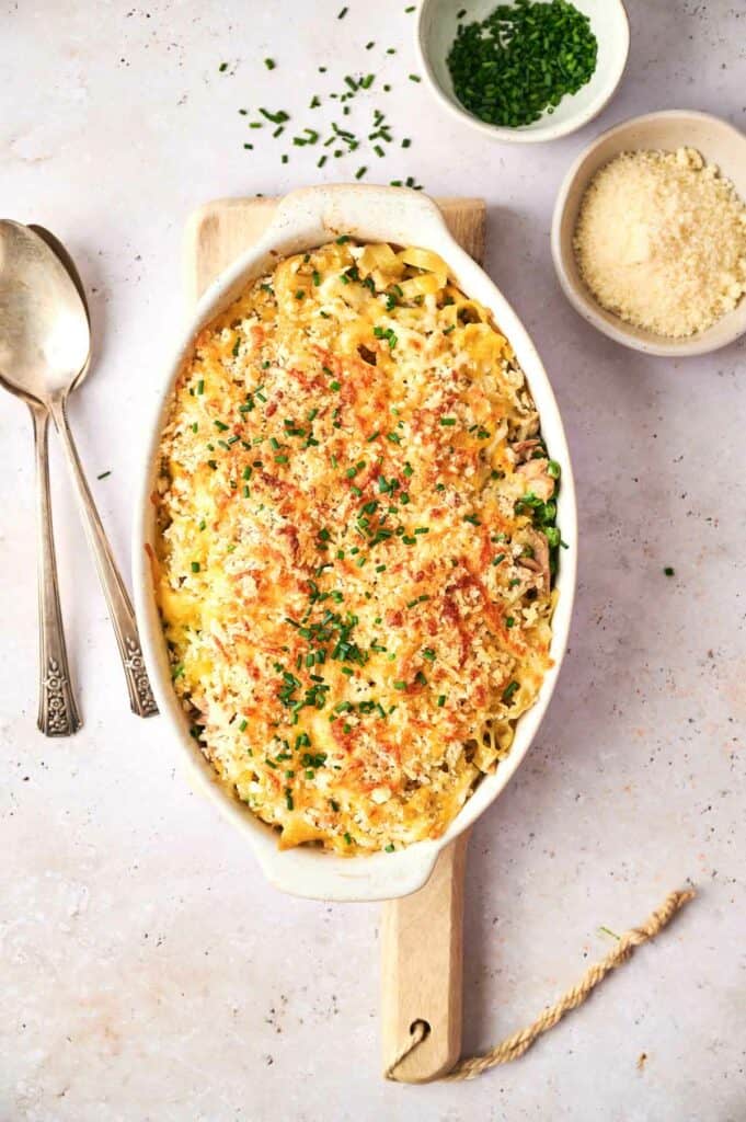 Tuna casserole in a white baking dish with spoon and fork on the side.