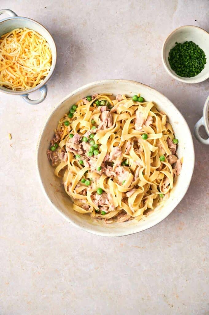pasta and other ingredients mixed in a bowl for a tuna casserole.