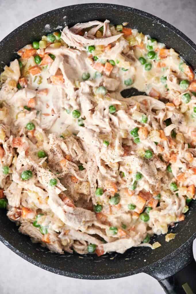 Creamy chicken pot pie skillet meal with chicken peas and carrots.