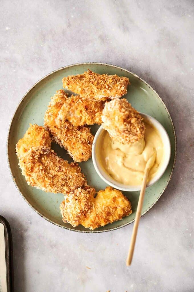 Chicken tenders with dip on a plate.