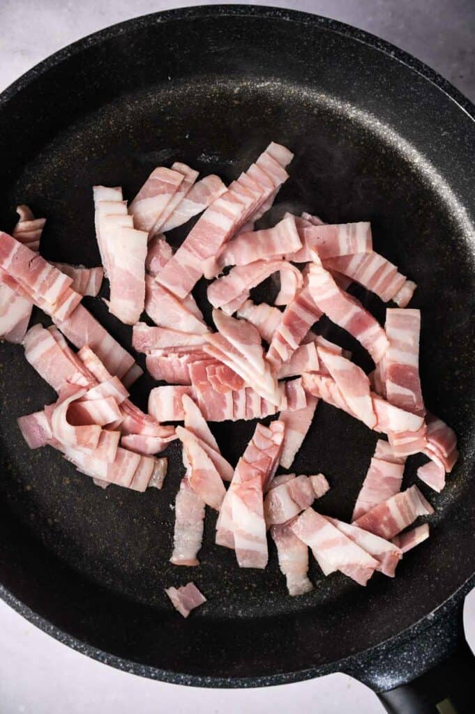Bacon slices in a skillet.