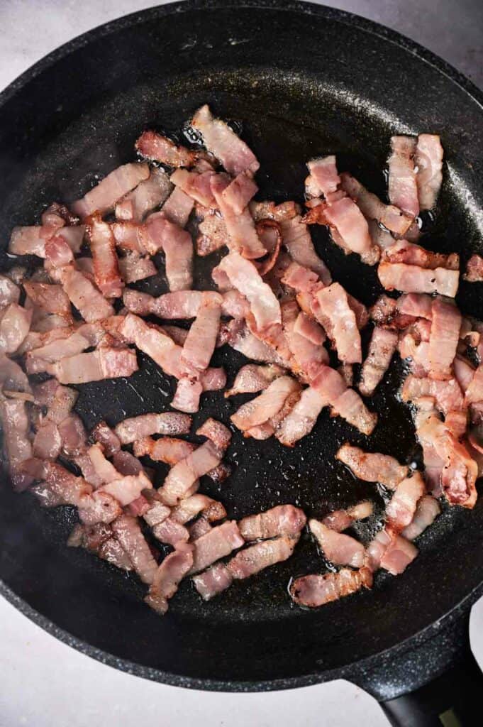 Bacon slices in a skillet.