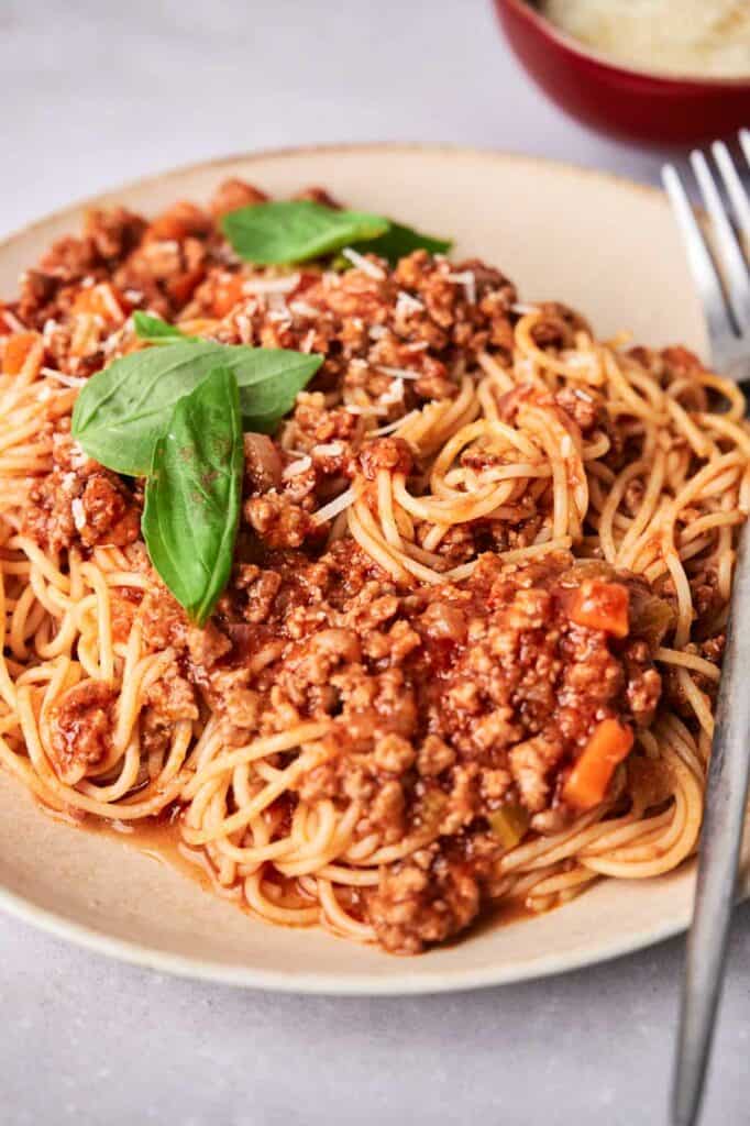 Spaghetti Bolognese on a plate with a fork on the side.