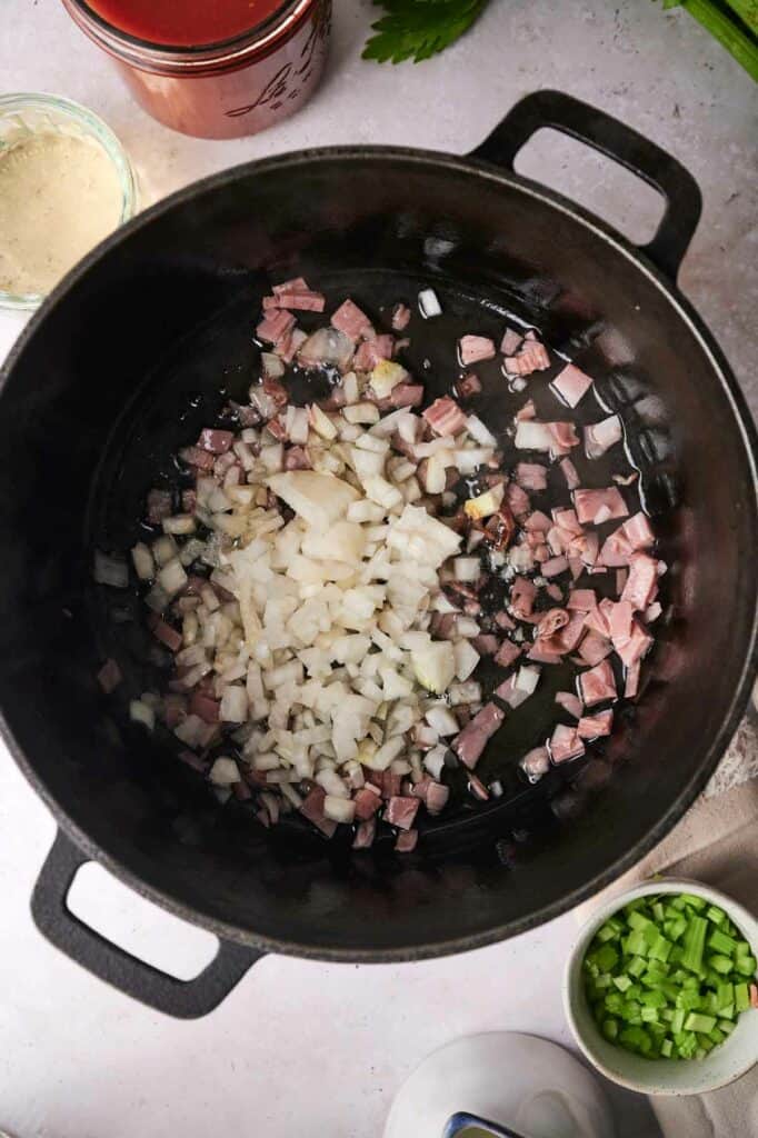 Diced onion and garlic being cooked in a skillet.