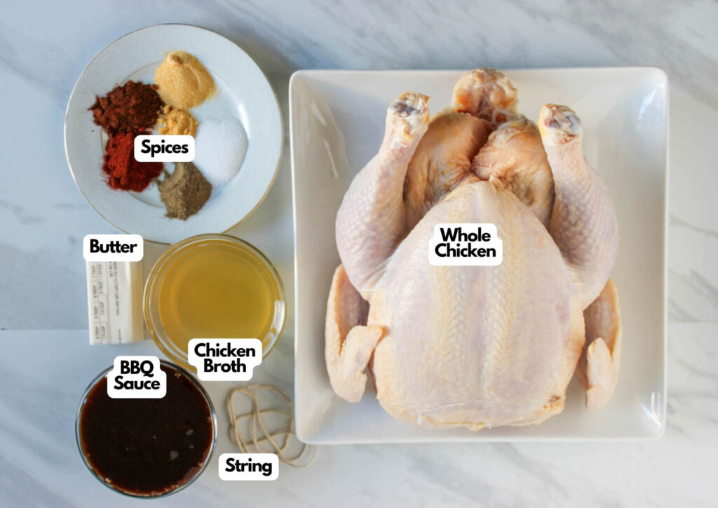 A whole baked BBQ chicken on a plate with labeled ingredients: spices, butter, chicken broth, BBQ sauce, and string arranged beside it.