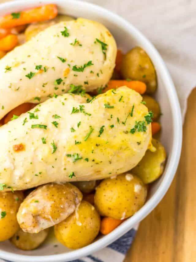 A bowl of chicken and dumplings with carrots and potatoes, garnished with chopped parsley.