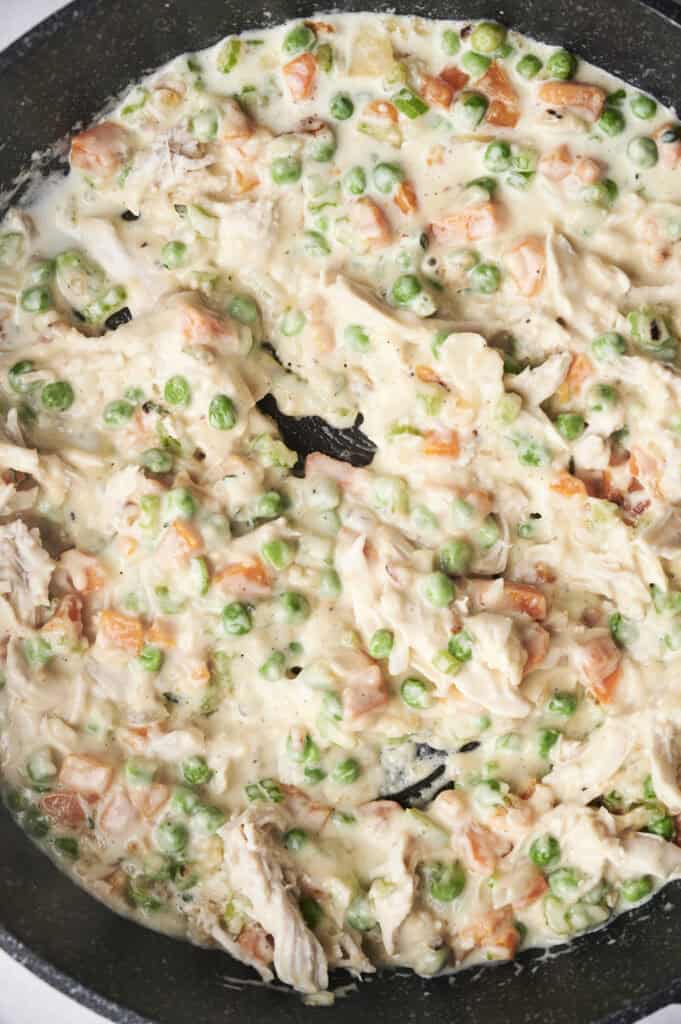 Shredded chicken is added into the vegetable mixture.