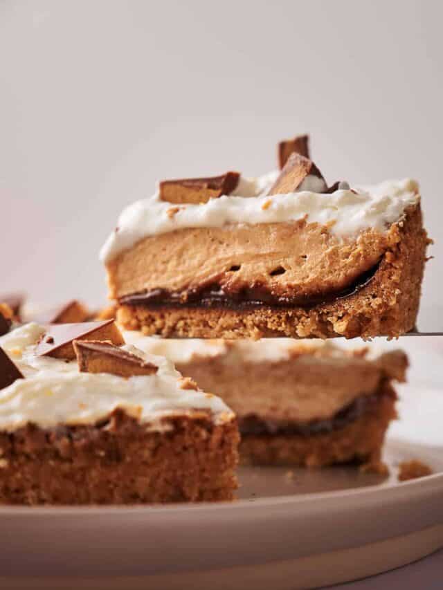 A slice of pie with a graham cracker crust, chocolate layer, peanut butter filling, whipped cream topping, and chocolate pieces.