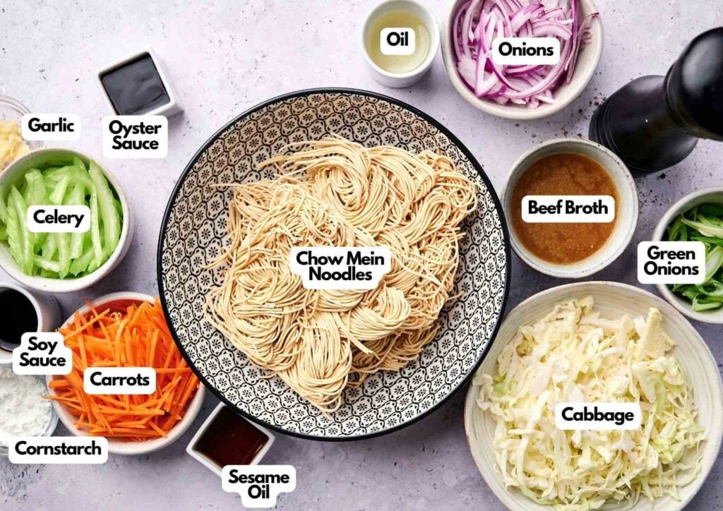 A bowl of chow mein noodles is surrounded by labeled ingredients: oil, onions, beef broth, green onions, cabbage, carrots, celery, oyster sauce, garlic, soy sauce, cornstarch, and sesame oil—perfect for making classic chow mein.