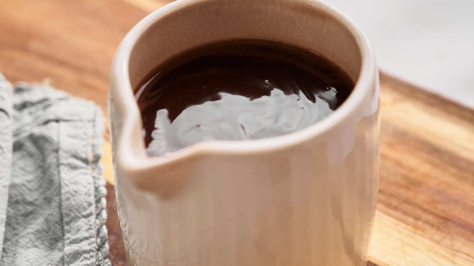 Hot fudge sauce being stirred in a pan.