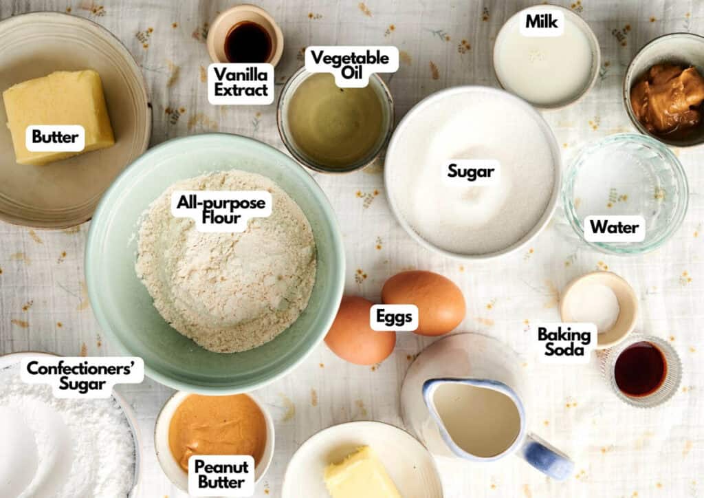 Various baking ingredients, including butter, all-purpose flour, eggs, milk, sugar, and peanut butter, are displayed on a table—perfect for creating a decadent Chocolate Pumpkin Patch Brownie Cake.