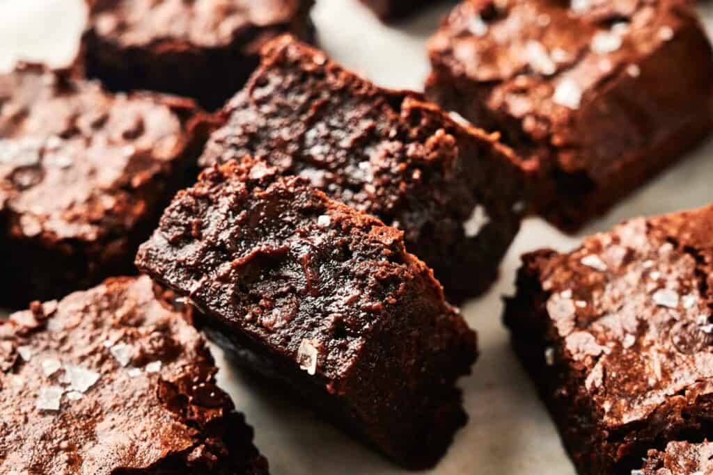 Close-up of several pieces of rich, fudgy air fryer chocolate brownies topped with a light sprinkle of sea salt.