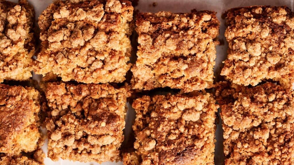 Close-up of eight square pieces of crumb cake with a golden-brown, crumbly top.