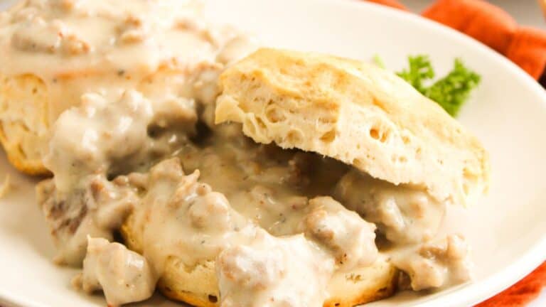 Biscuits topped with sausage gravy on a white plate.