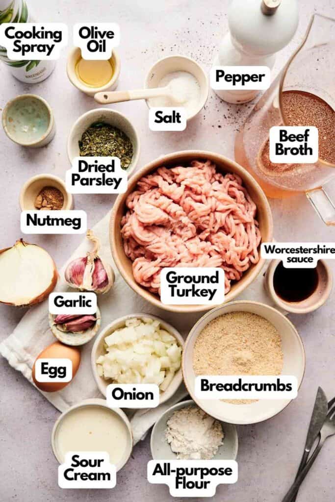 Ingredients for turkey meatballs are arranged, featuring ground turkey, breadcrumbs, onion, garlic, egg, sour cream, flour, nutmeg, dried parsley, salt and pepper. Add a splash of beef broth and olive oil with a hint of Worcestershire sauce for extra flavor.