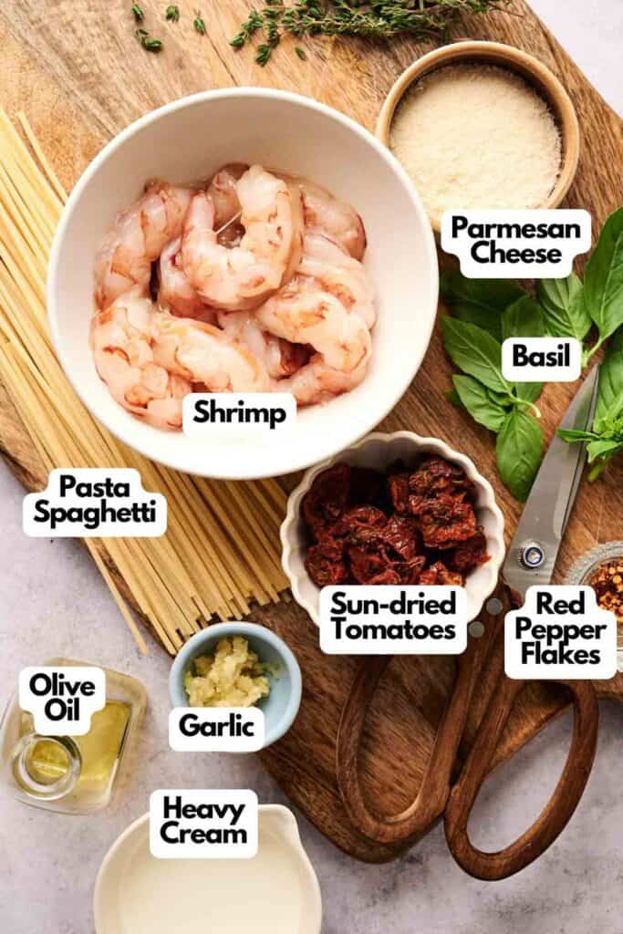Marry me shrimp pasta with parmesan, basil, sun-dried tomatoes, red pepper flakes, garlic-infused olive oil, and a touch of heavy cream awaits on the countertop.
