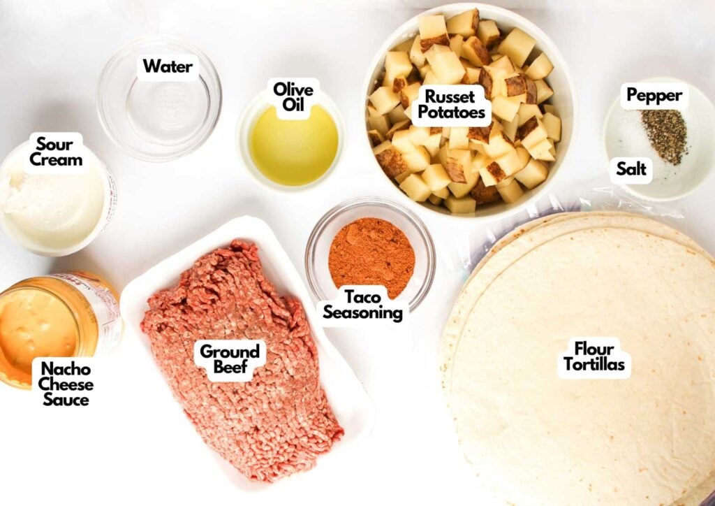 Top-down view of ingredients for a Beef and Potato Burrito Taco Bell Copycat: ground beef, russet potatoes, flour tortillas, taco seasoning, nacho cheese sauce, sour cream, olive oil, water, salt, and pepper.