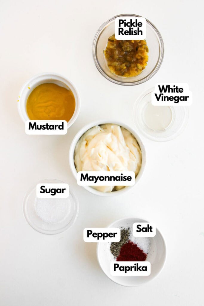 Five labeled ingredients for a sauce on a white surface&mdash;pickle relish, white vinegar, mustard, mayonnaise, plus a bowl with sugar, pepper, salt, and paprika&mdash;perfect for adding flavor to your Big Mac Sloppy Joes.