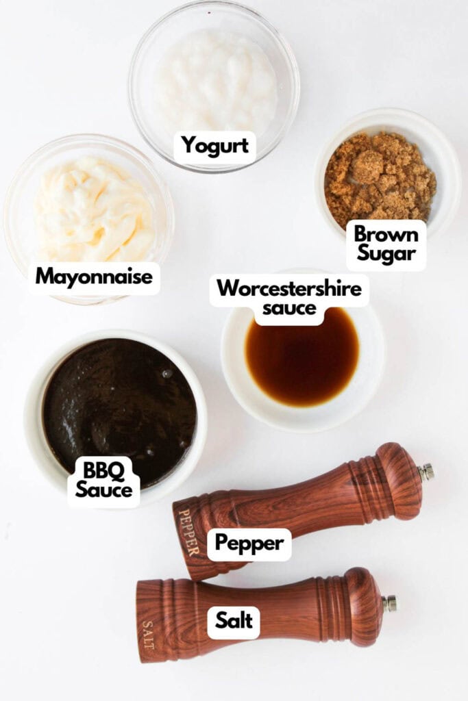 A flat lay of labeled ingredients for Taco Pasta Salad, including yogurt, mayonnaise, brown sugar, Worcestershire sauce, BBQ sauce, salt, and pepper on a white background.