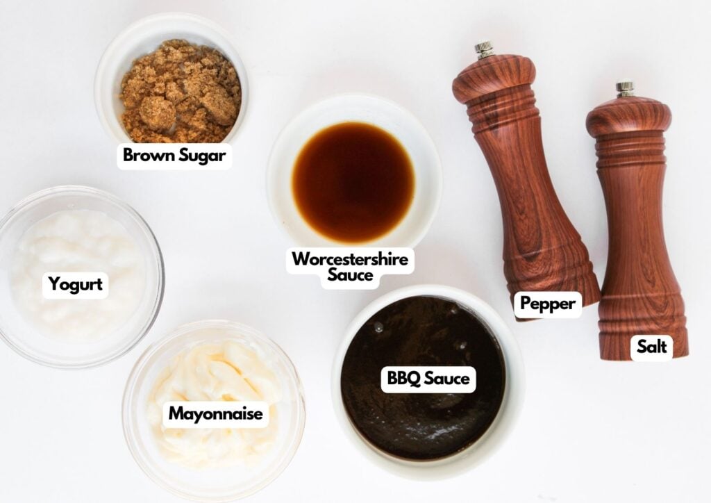 Six labeled ingredients for a sauce on a white surface, perfect for Taco Pasta Salad: brown sugar, Worcestershire sauce, pepper, salt, BBQ sauce, mayonnaise, and yogurt in small bowls, with pepper and salt mills.