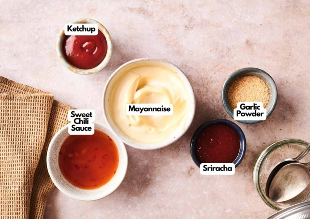 Bowls containing mayonnaise, ketchup, sweet chili sauce, sriracha, garlic powder&mdash;and a special bowl of Boom Boom Sauce&mdash;are arranged on a countertop next to a napkin and utensils. Labels identify each ingredient.