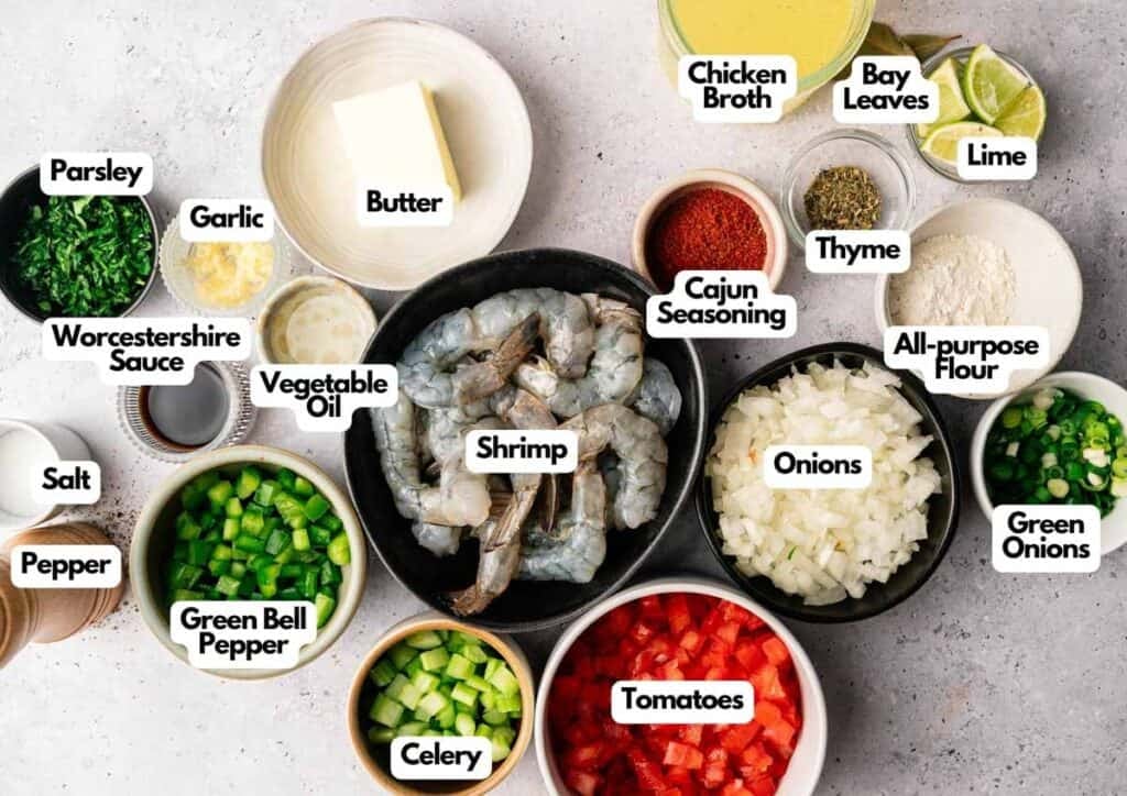 Top-down view of ingredients for Shrimp Etouffee, including raw shrimp, chopped vegetables, spices, butter, chicken broth, lime, and seasonings, each labeled with its name.