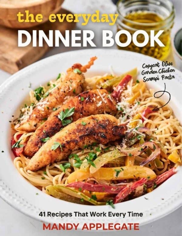 A plate of pasta with grilled chicken strips and vegetables on the cover of "The Everyday Dinner Book" by Mandy Applegate.