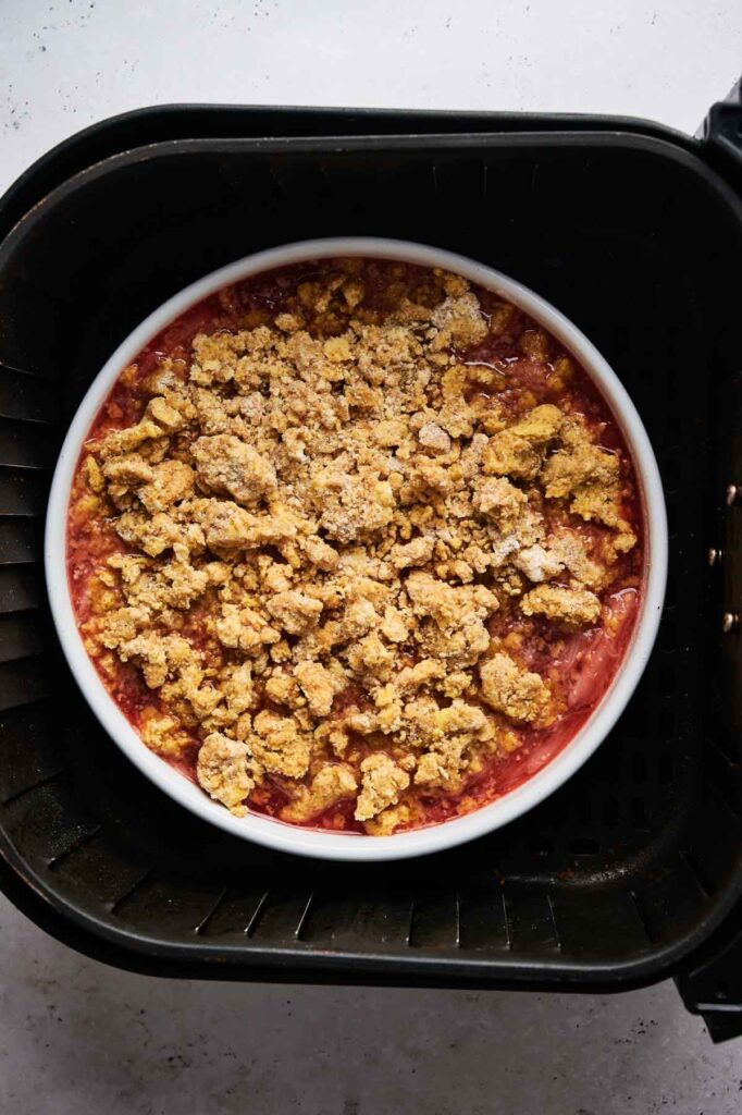 Rhubarb crisp with crumble topping in a white baking dish, ready to air fry