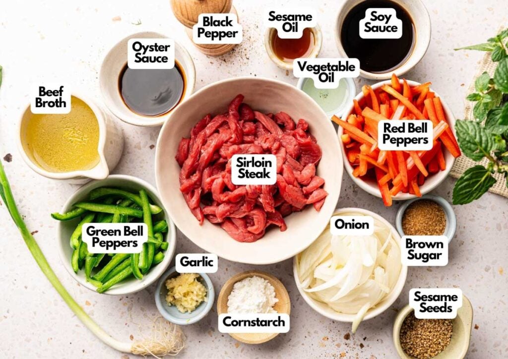 Top-down view of labeled ingredients for a Panda Express Black Pepper Sirloin Steak stir-fry, featuring sirloin steak, bell peppers, onion, garlic, cornstarch, sauces, seasonings, and beef broth arranged on a white surface.