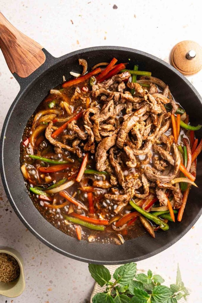Seared beef strips added to stir-fried vegetables coated in a glossy black pepper sauce.