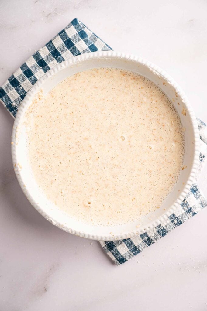 A white bowl filled with a light, creamy mixture inspired by Panda Express Honey Walnut Shrimp sits on a blue and white checkered cloth on a marble surface.